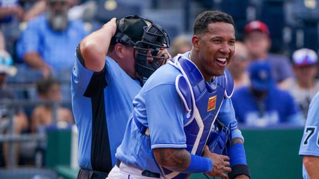 Jun 20, 2021; Kansas City, Missouri, USA; Kansas City Royals catcher Salvador Perez (13) laughs as he assures the umpires he s not hurt after getting hit with a foul tip in the seventh inning against the Boston Red Sox at Kauffman Stadium. Mandatory Credit: Denny Medley-USA TODAY Sports